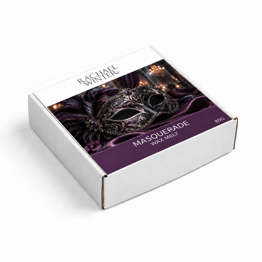 A white cardboard box of Rachel Winters Masouerade Wax Melt, featuring a purple and black masquerade mask graphic on the lid, set against a clean white background.
